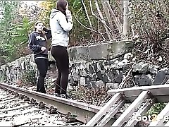 Friends piss by the railroad tracks